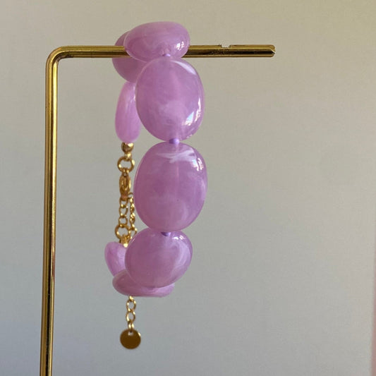 Handgemaakte en verstelbare armband in lila acryl kralen, afgewerkt met een hoogwaardige stainless steel sluiting