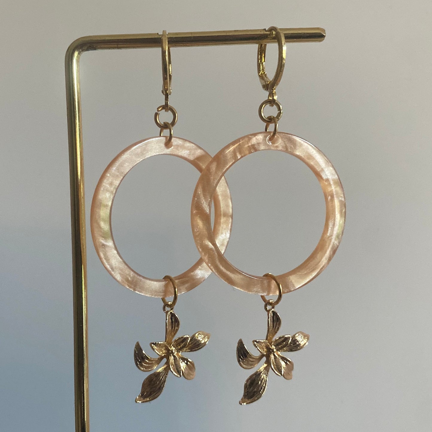 Statement oorbellen met 14K vergulde bloemen en een perzikkleurige resin hanger.