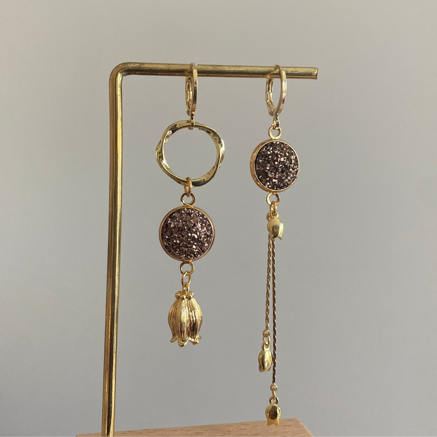 Asymmetrische 14k vergulde oorbellen met rosékleurige glitter cabochon, tulpbedels en een kwastje met mini tulpjes.