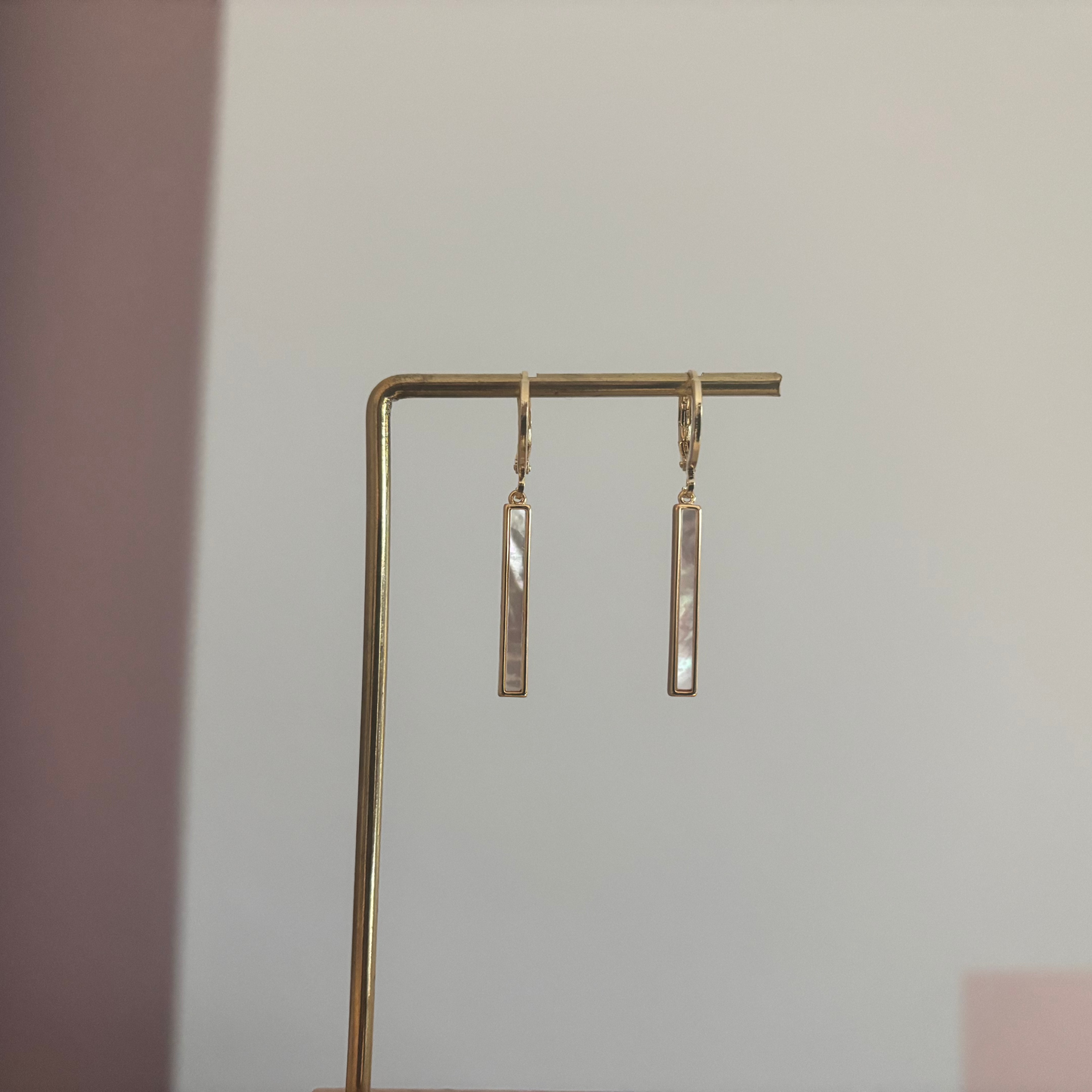 Korte 14k vergulde oorbel met shell staafje, circa 3 cm lang.