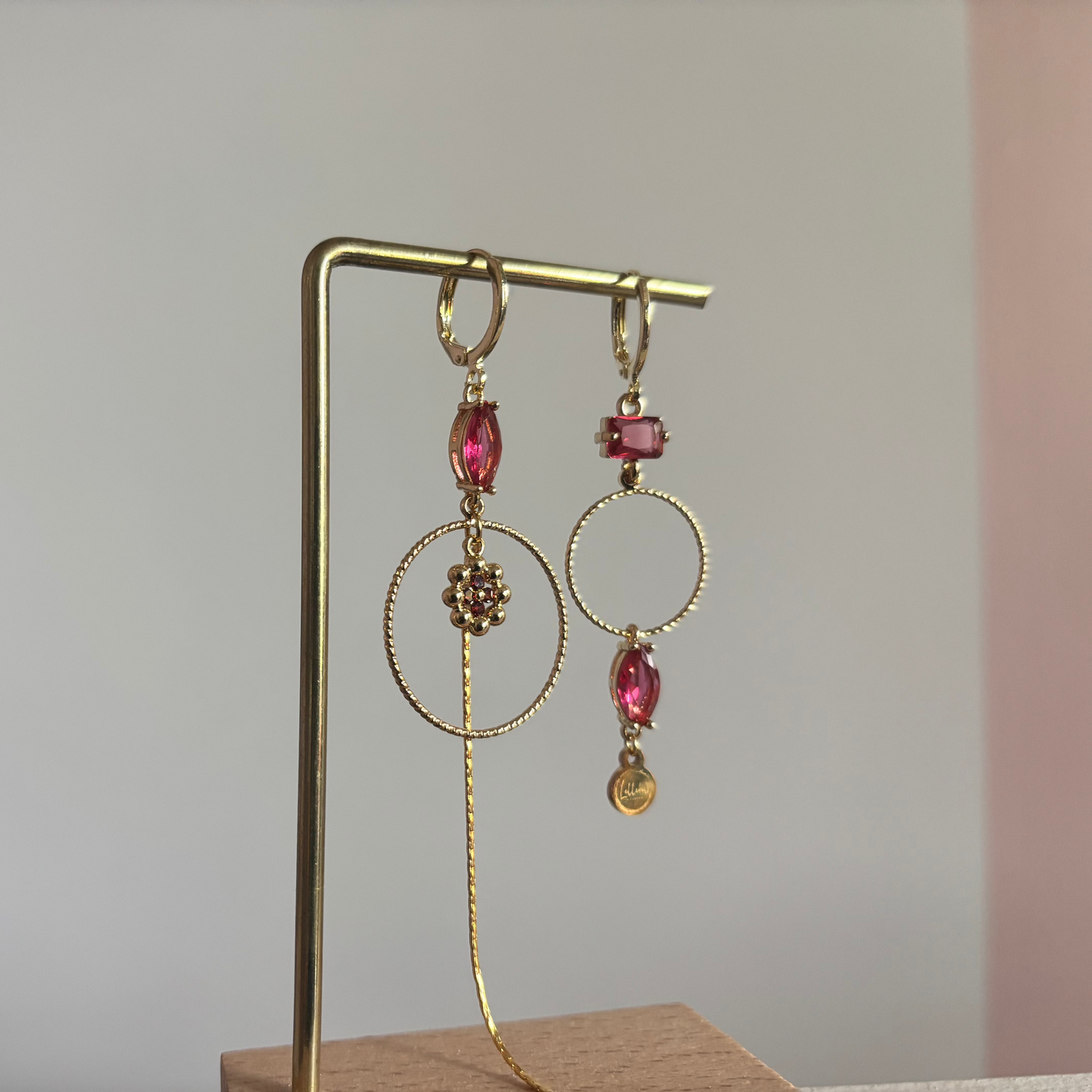 Asymmetrische 14k vergulde oorbellen Becky met magenta glasbedel, minimalistische ring, strengetje en bloemetje, circa 7 cm lang.
