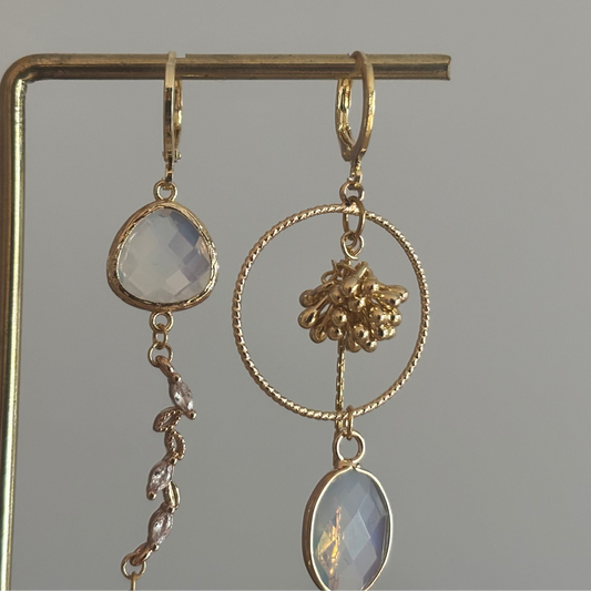 Asymmetrische 14k vergulde oorbellen met opaalkleurige natuursteentjes, bijtje met zirkonia en trosje, circa 6 cm lang.