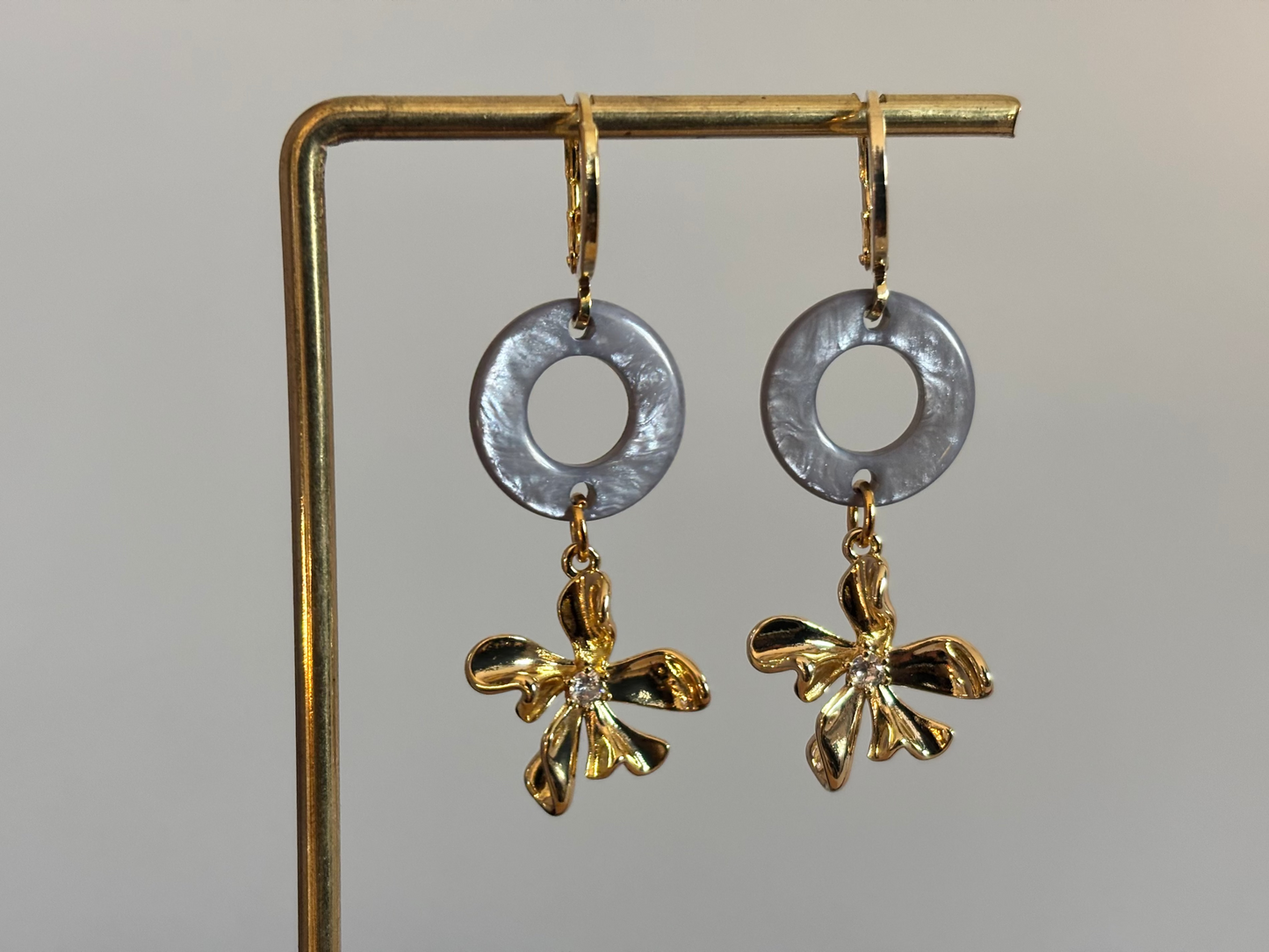 14K vergulde oorbellen met een ronde Polaris hanger en een gouden bloemetje met zirkonia.