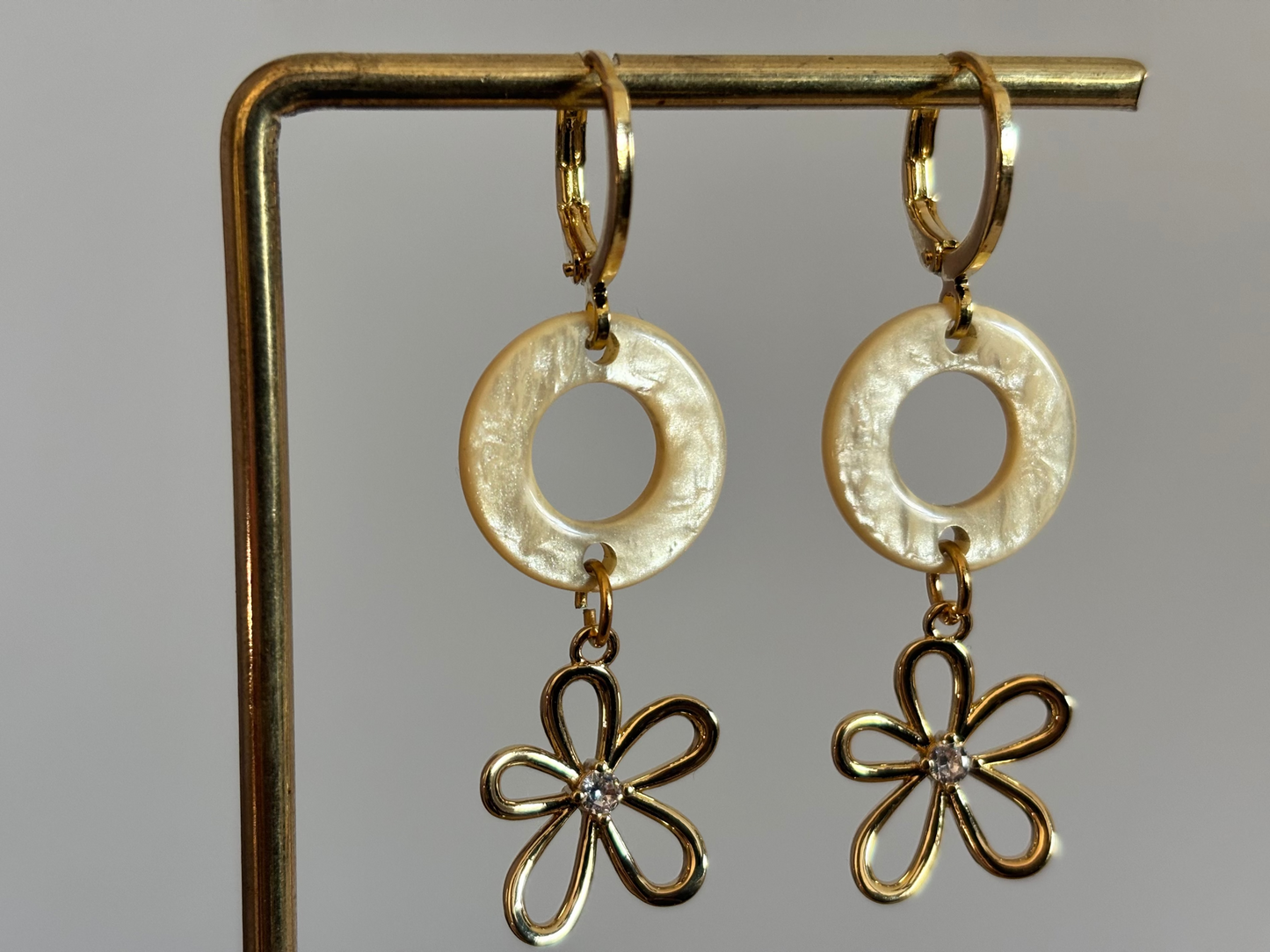 14K vergulde oorbellen met een ronde Polaris hanger en een gouden bloemetje met zirkonia.