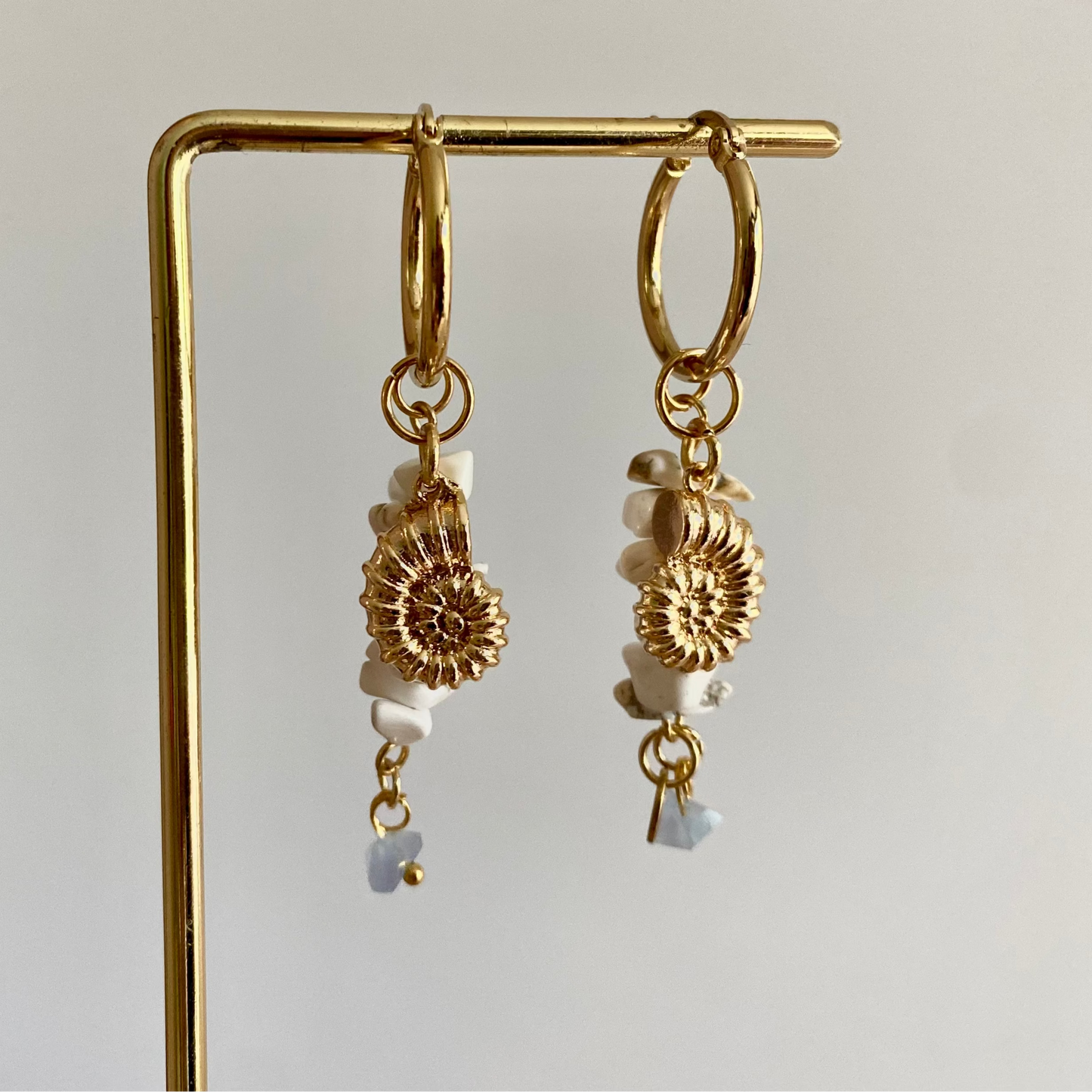 Oorbellen met RVS hoops met daaraan witte natuurstenen, een mini blauwe glasbedel en 14K vergulde koraalpedels.