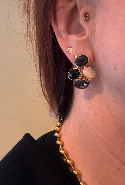 Model met de 14k vergulde oorstekers met catseye natuurstenen in zwart, grijs en wit