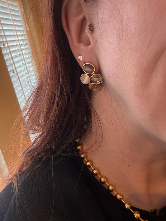 Model met 14k vergulde oorstekers met catseye natuurstenen in taupe, beige, parelmoer en champagne