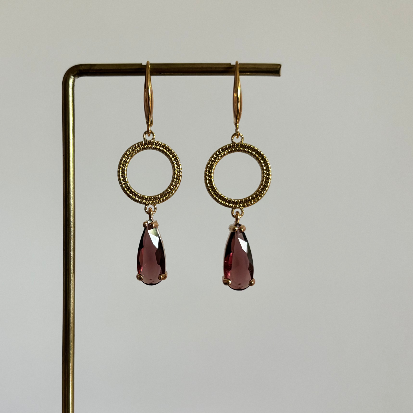 Ontdek oorbellen Druppel Mir Burgundy. Een klassieke goudkleurige set (14k verguld) met bewerkte ringen en dieprode kristaldruppels. Bestel online
