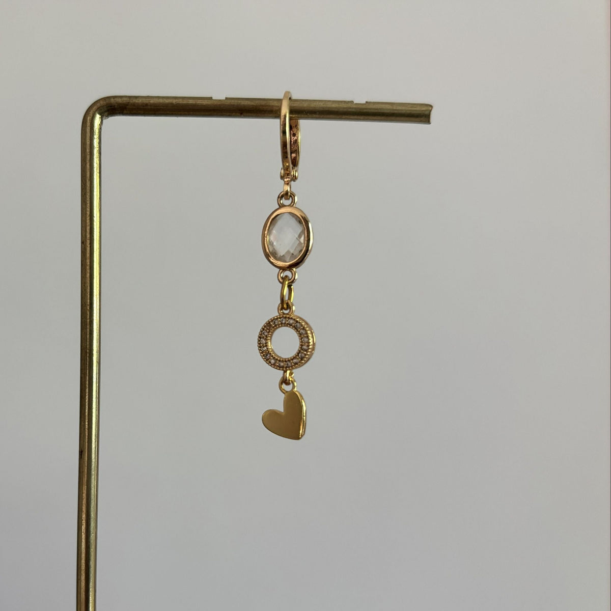 14k vergulde losse oorring Earparty Liv met een verticale hanger bestaande uit een ovale kristalsteen, zirkonia ringetje en goudkleurig hartje.