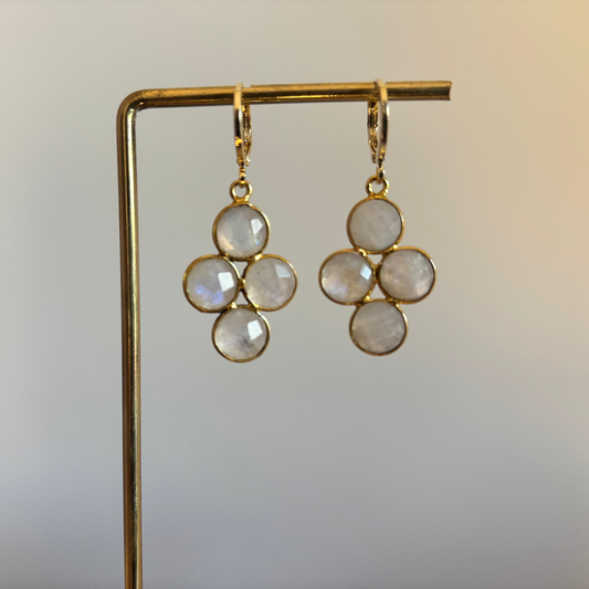 "Kleine gouden oorbellen met een ronde witte maansteen die verdeeld is in vier gelijke vlakken."