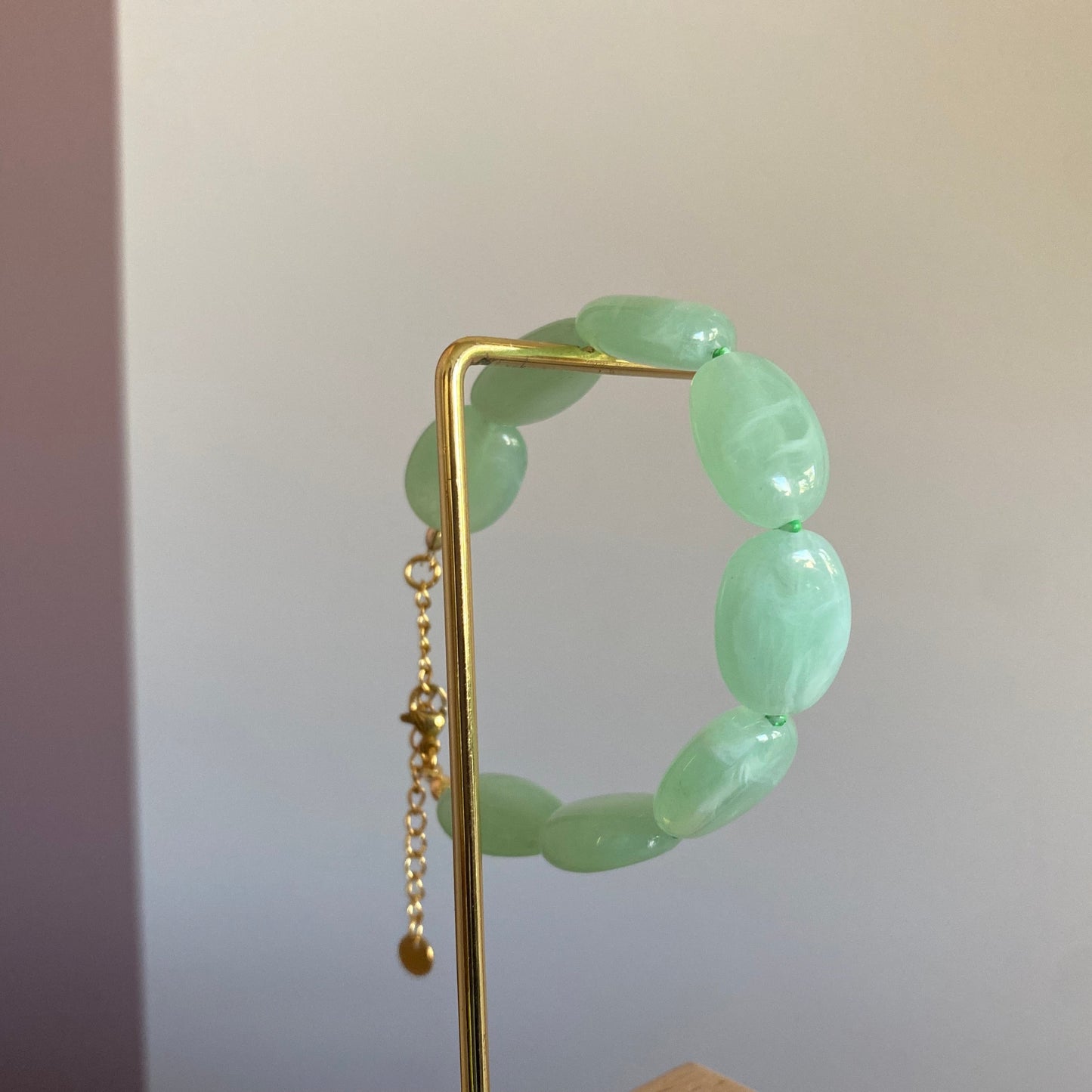 Handgemaakte en verstelbare armband met zeegroene opvallende acrylkralen afgewerkt met stainless steel kettinkje.