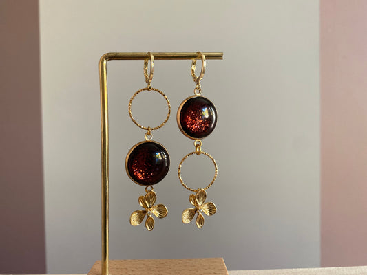 Asymmetrische 14k vergulde oorbellen met roodbruine glitter cabochon en zwarte glassteen — feestelijke variant van het populaire model Annick
