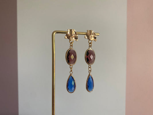 Oorsteker met gewrongen look, bordeauxrode ovale glasbedel en felblauwe druppelvormige glasbedel"