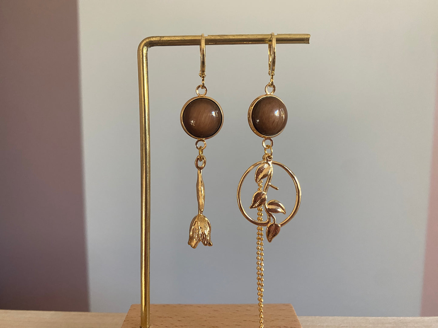 Asymmetrisch mismatch paar met een donkerbruine cabochon en 14k vergulde Roos, rechts donkerbruine cabochon, blad bedel en verguld kwastje