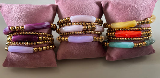 8k goldplated bolletjes en een grote, gebogen kunststof kraal met een subtiel gemarmerd effect in diverse kleuren zoals lila, fuchsia, oranje en mintgroen, paars, okergeel, koraal, zeegroen.