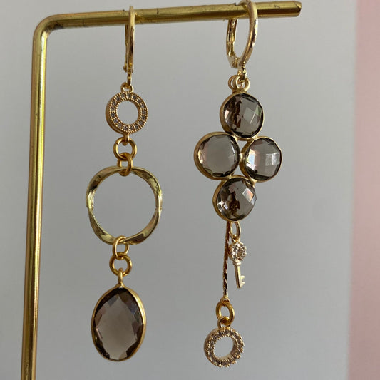 Lola asymmetrische oorbellen met taupekleurige glazen bedel, eigen ontworpen stenen, mini twisted ring, zirkonia steentjes en kwastje met sleuteltje, 14k verguld