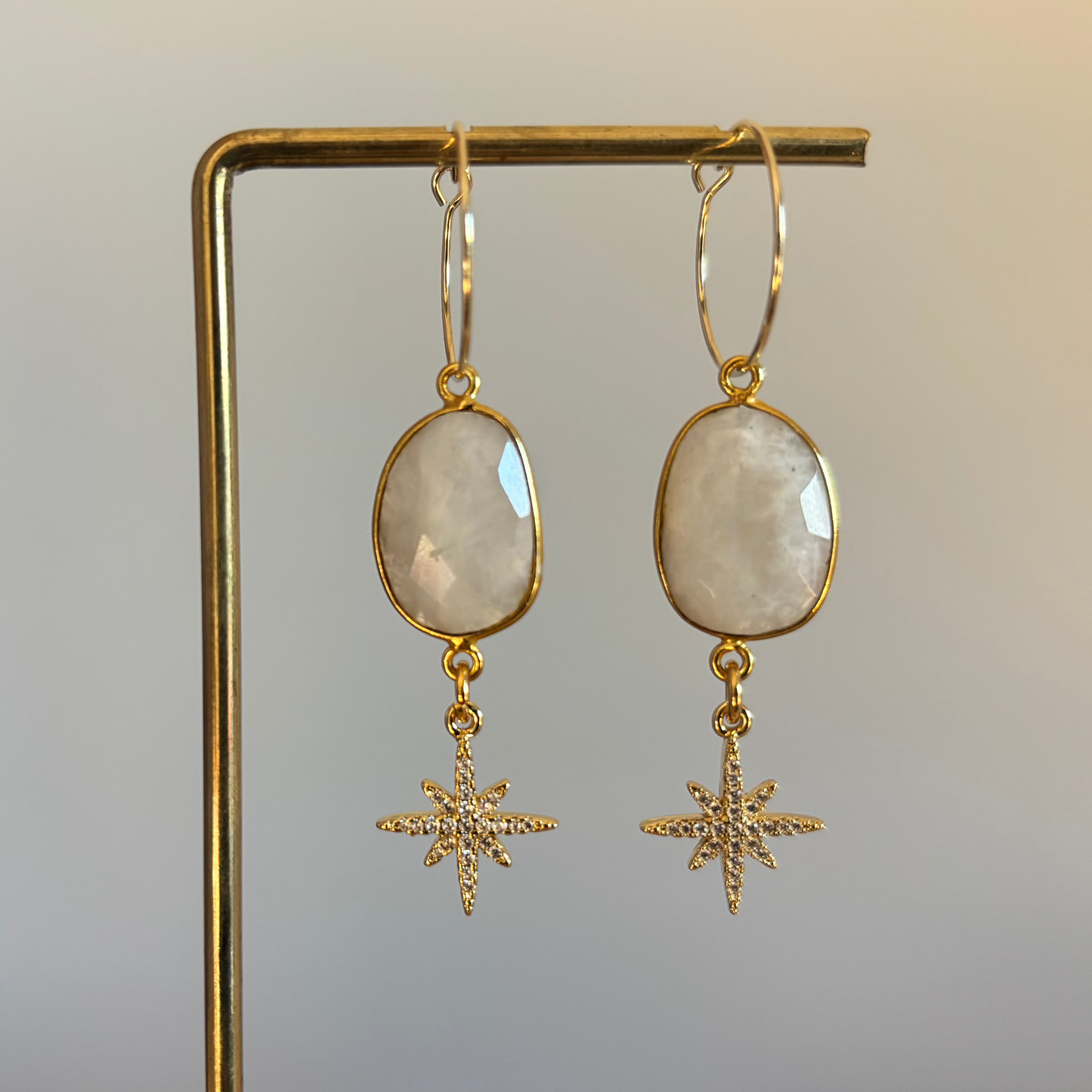 "14k vergulde oorbellen met ovale maansteen en stervormige hangers van zirkonia."
