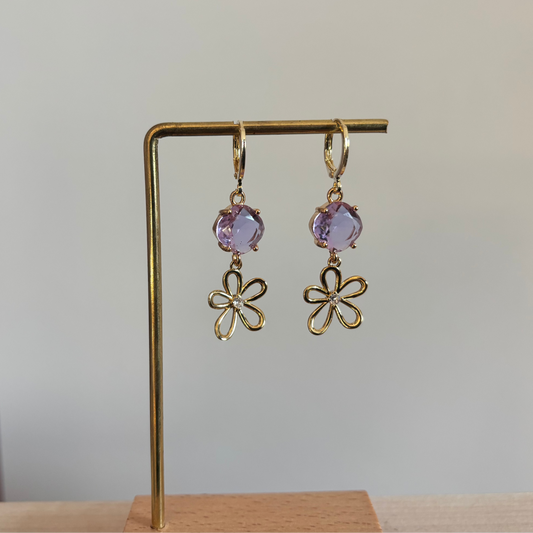 Korte 14K vergulde oorbellen met ronde lila glasbedel en een gouden bloemetje met zirkonia.