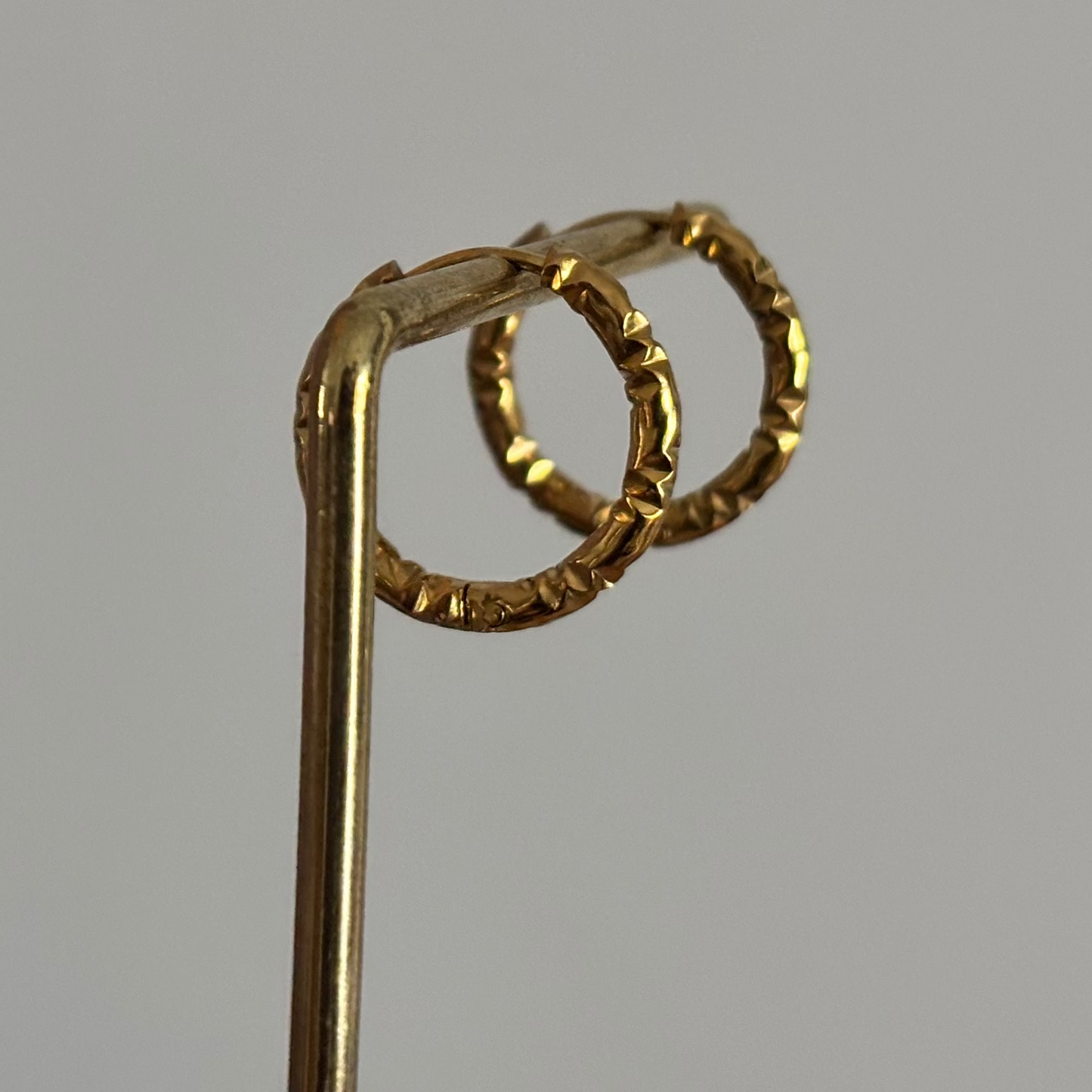 Alt-tekst: 18K goudkleurige creolen van 14 mm met een stoer bewerkt effect in de plating.