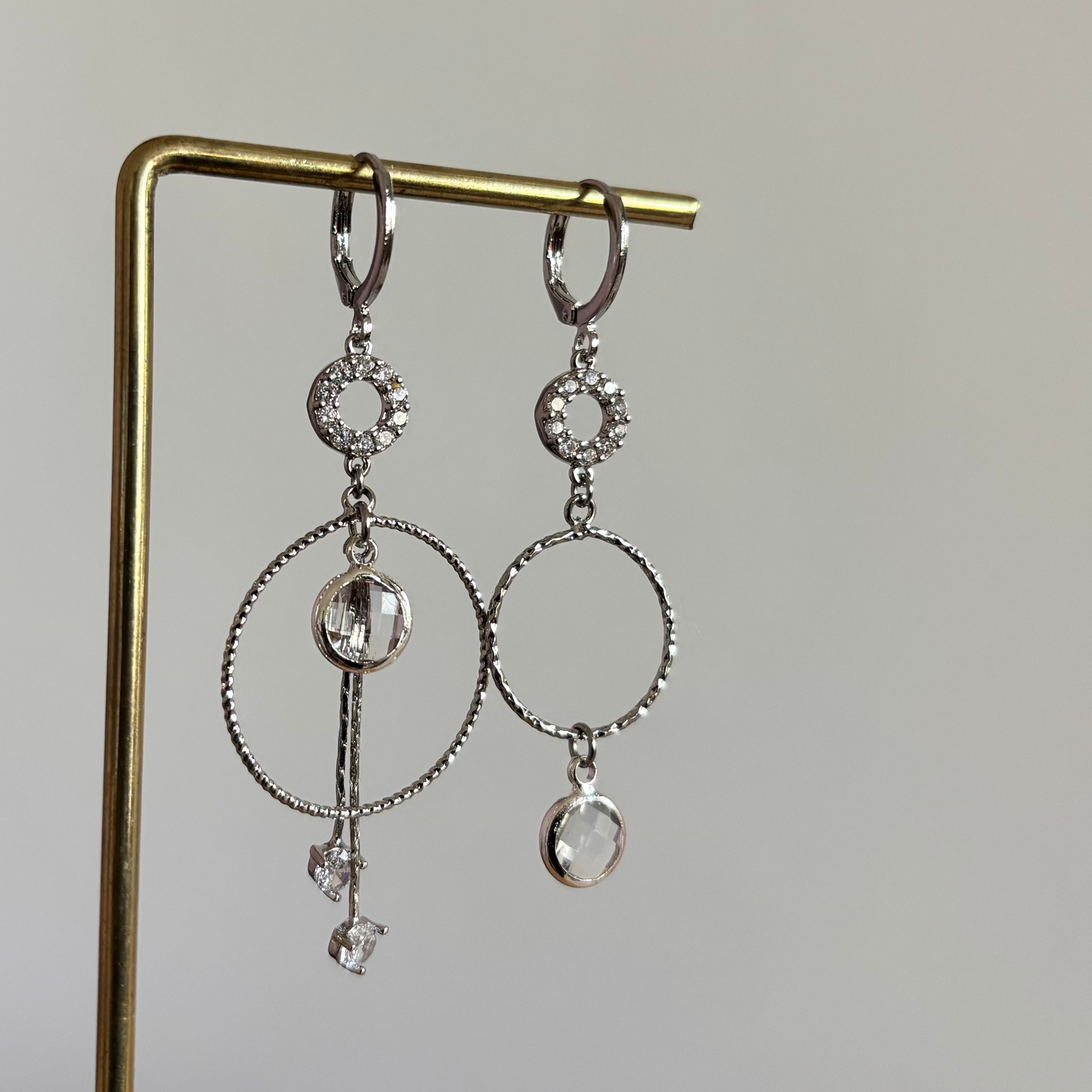 Een foto van mismatch paar oorbellen Sandra Zilver, met de blanke glasbedels.