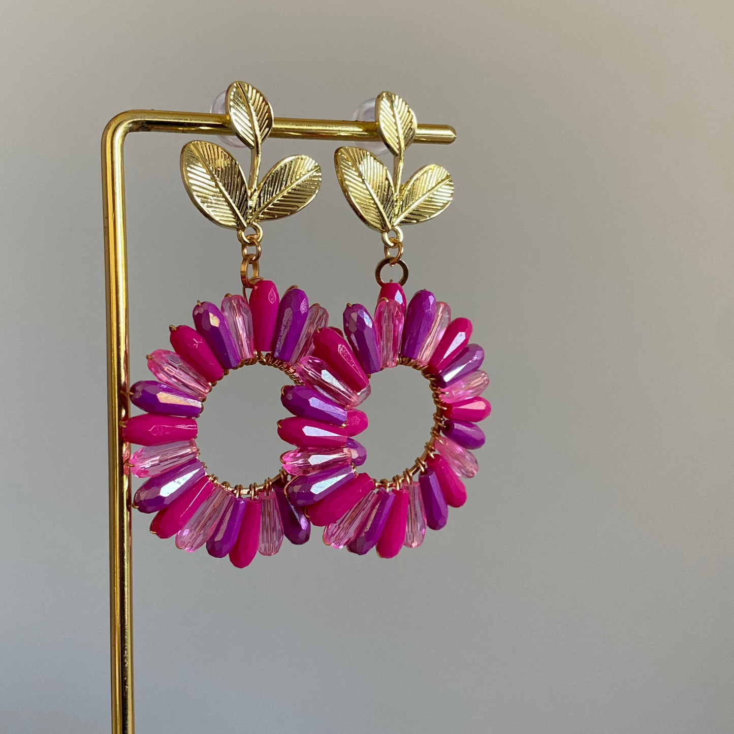 Statement bloem oorbellen met 14K vergulde blad stekers en een bloemachtige hanger in knalroze, blauwtinten, zwart en champagne