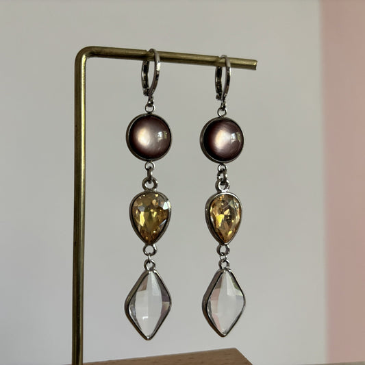 Zilverkleurige oorhangers 'Oukje Bruin' in zilver met een ronde bruine cabochon, een traanvormige amberkleurige glassteen en een heldere ruitvormige hangende steen.