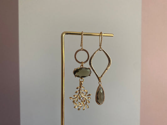 Asymmetrisch oorbelpaar met taupe glasbedel, 14k vergulde takvormige bedel en gehamerde druppel