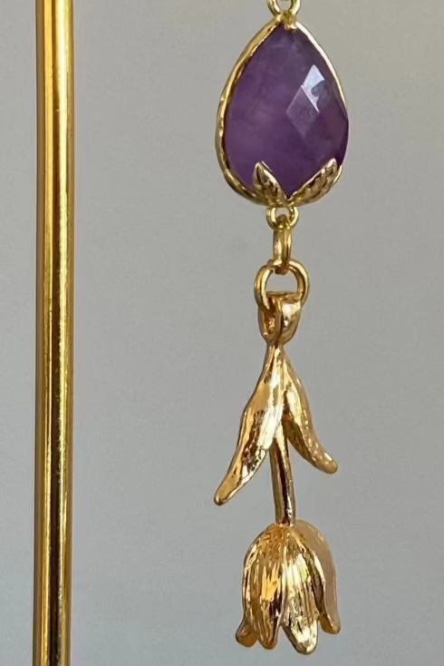 Asymmetrische 14K vergulde oorbellen met natuurstenen bedel en afgewerkt en 14K vergulde tulpen en bladeren.