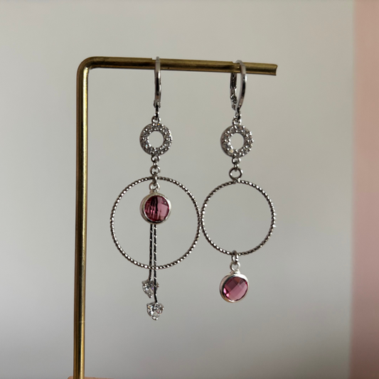 Een foto van mismatch paar oorbellen Sandra Zilver, met de roze glasbedels.