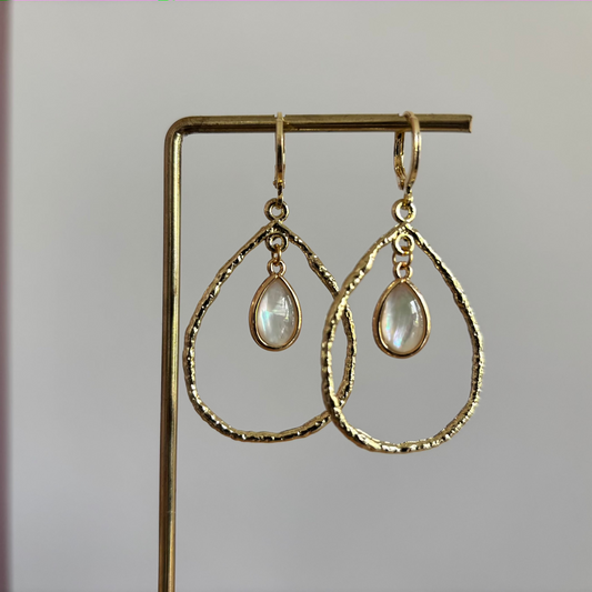 Foto van oorbellen "Soraya". Een gehamerde druppelhanger met parelmoer glasbedel. Handgemaakt paar oorbellen in 14k verguld.