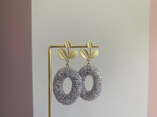 Handgemaakte oorbellen van 14K gouden vergulde bladstekers boven een ronde kralenhanger in zachtgrijze tinten