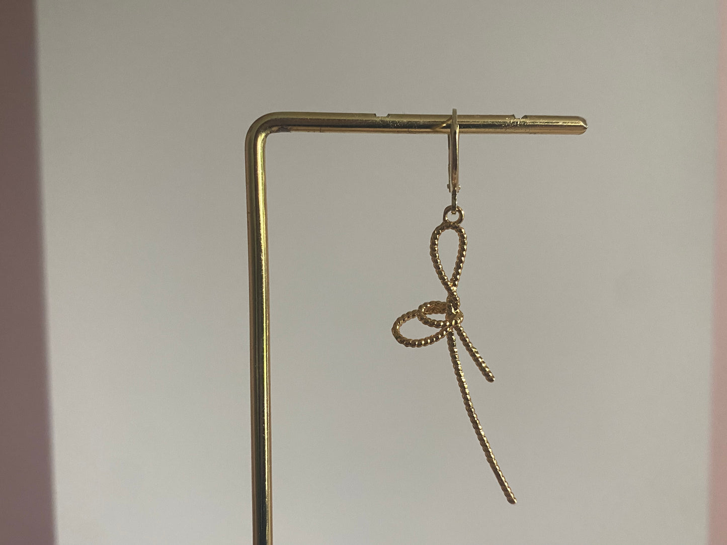 Handgemaakte earparty oorbel met een 14K verguld oorringetje en een stainless steel opengewerkte strik