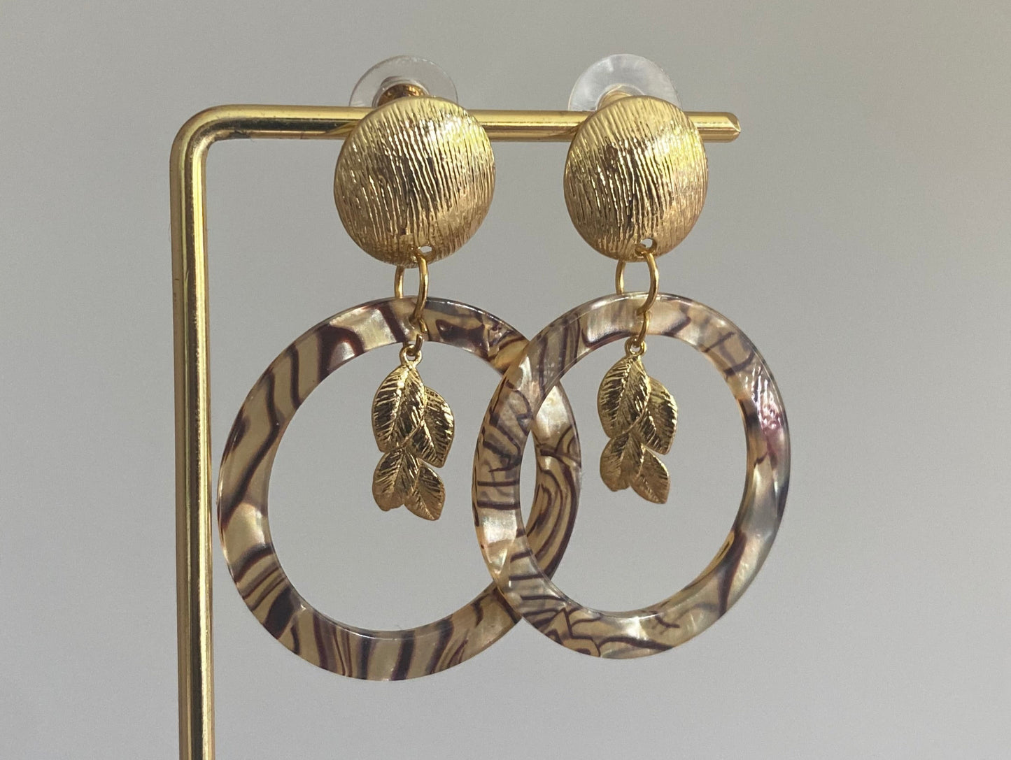 Gemarmerde resin hanger met 14K vergulde bladbedel aan een 14K vergulde gehamerde steker.