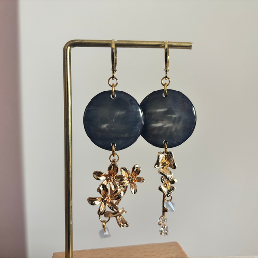 Gouden 14k vergulde asymmetrische oorbellen Senne met ronde blauwgrijze hangers en bloemdetails.