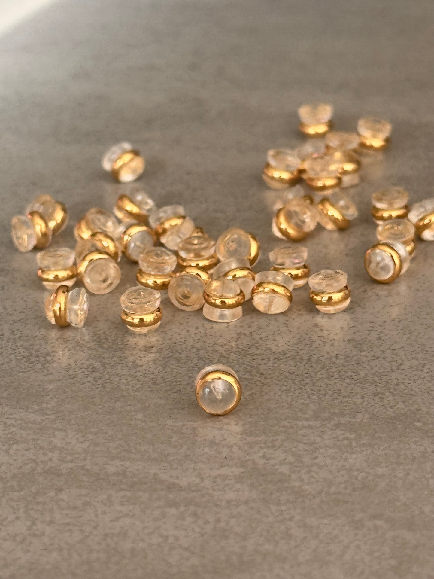 Kunststoffen oorbel stoppers van transparante kunststof en afgewerkt met een gouden randje