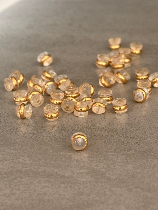 Kunststoffen oorbel stoppers van transparante kunststof en afgewerkt met een gouden randje