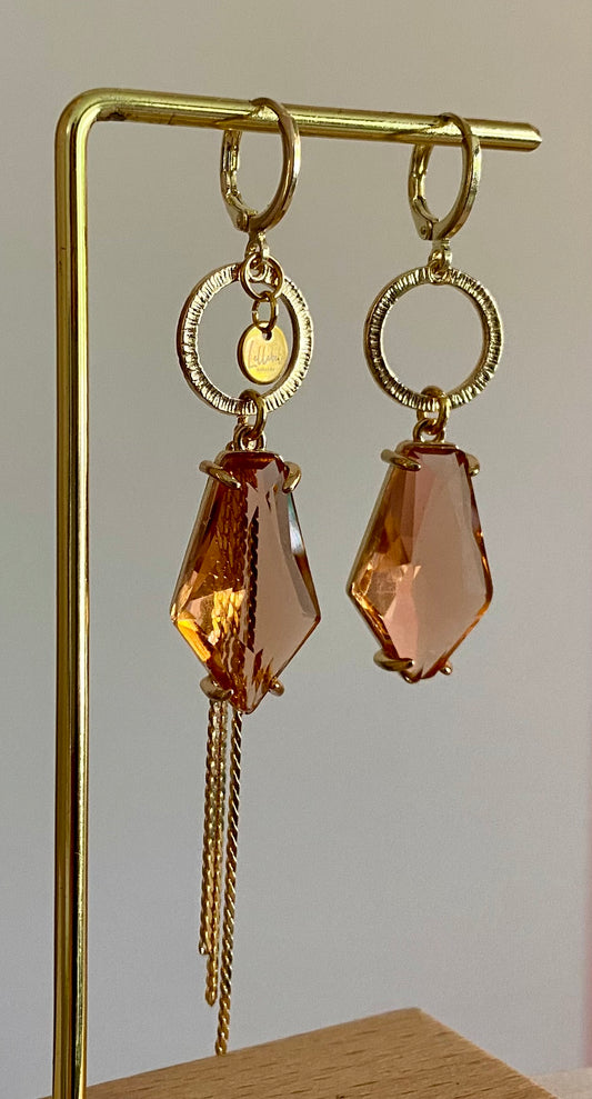 Asymmetrische oorbellen met gehamerde gouden ring, klein merk logo, roest oranje glasbedel in de vorm van een hexagon en gouden streng 