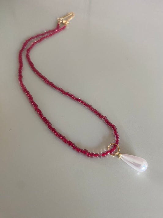 Rode glaskralen of rijstkralen ketting met een parel bedel 