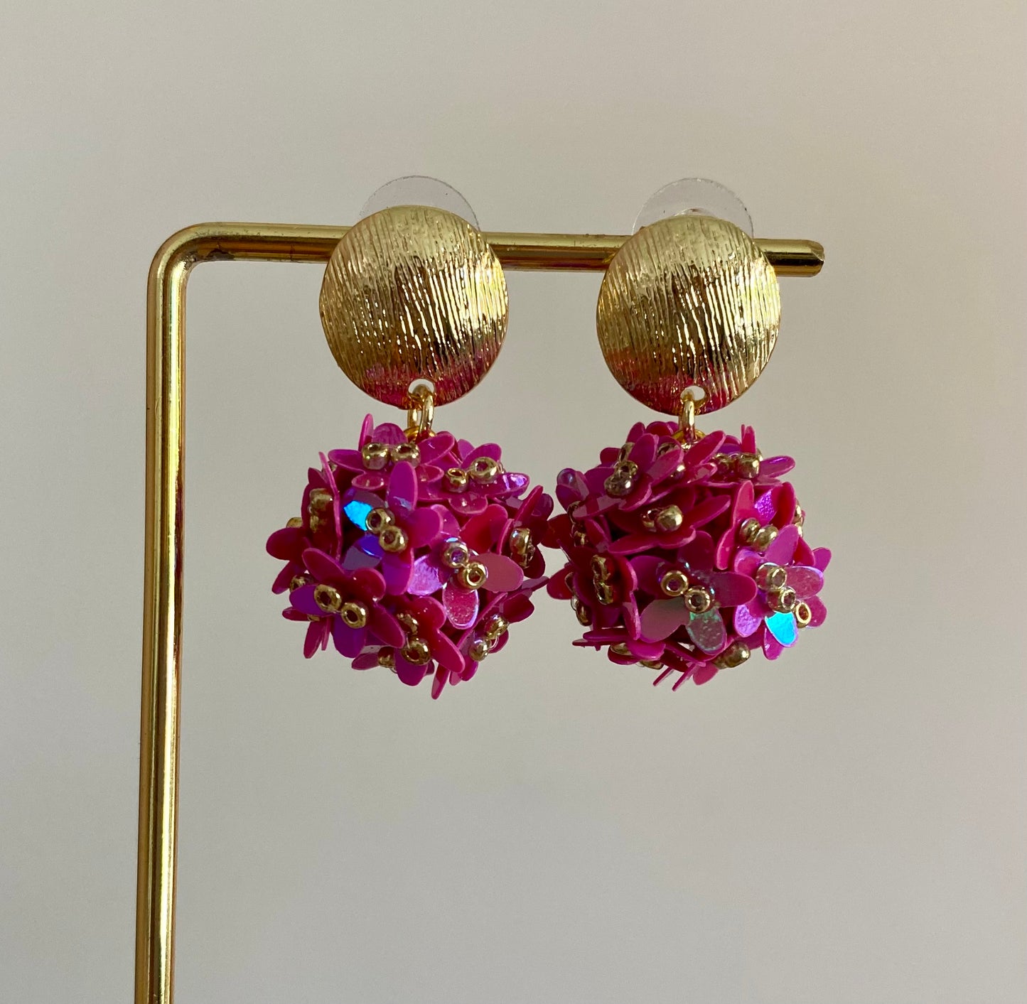 Bolletjes oorbel van holografische bloemetjes en gehamerde ronde RVS stekers in fuchsia tinten 
