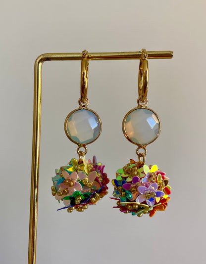 Bolletjes oorbel van holografische bloemetjes in regenboog kleuren, een parelmoeren glasbedel en RVS oorringen 