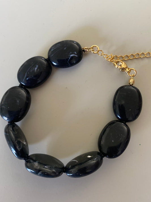 Detailfoto van Handgemaakte en verstelbare armband in zwarte acryl kralen, afgewerkt met een hoogwaardige stainless steel sluiting 