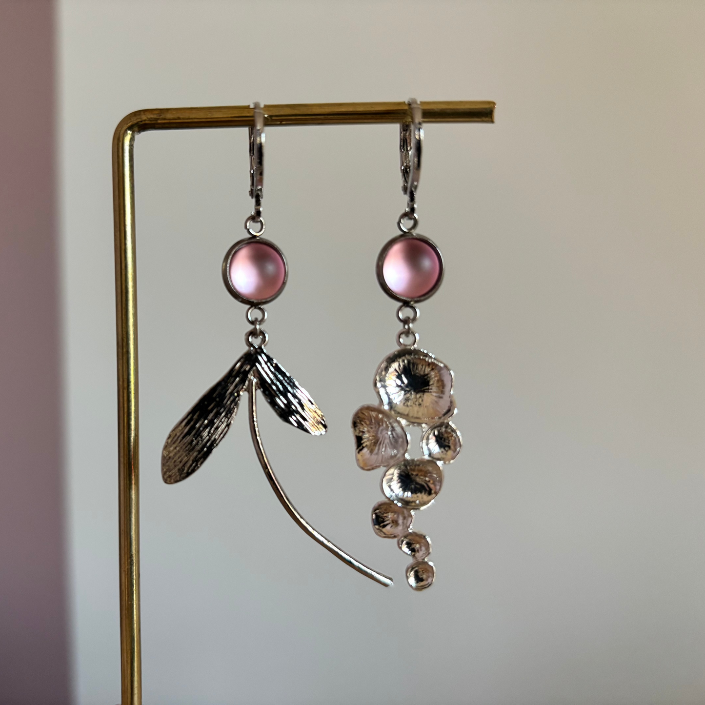 Asymmetrische vergulde oorbellen Abby met rozekleurige cabochon, honingraathanger links en fantasiebedel rechts, circa 5 cm lang