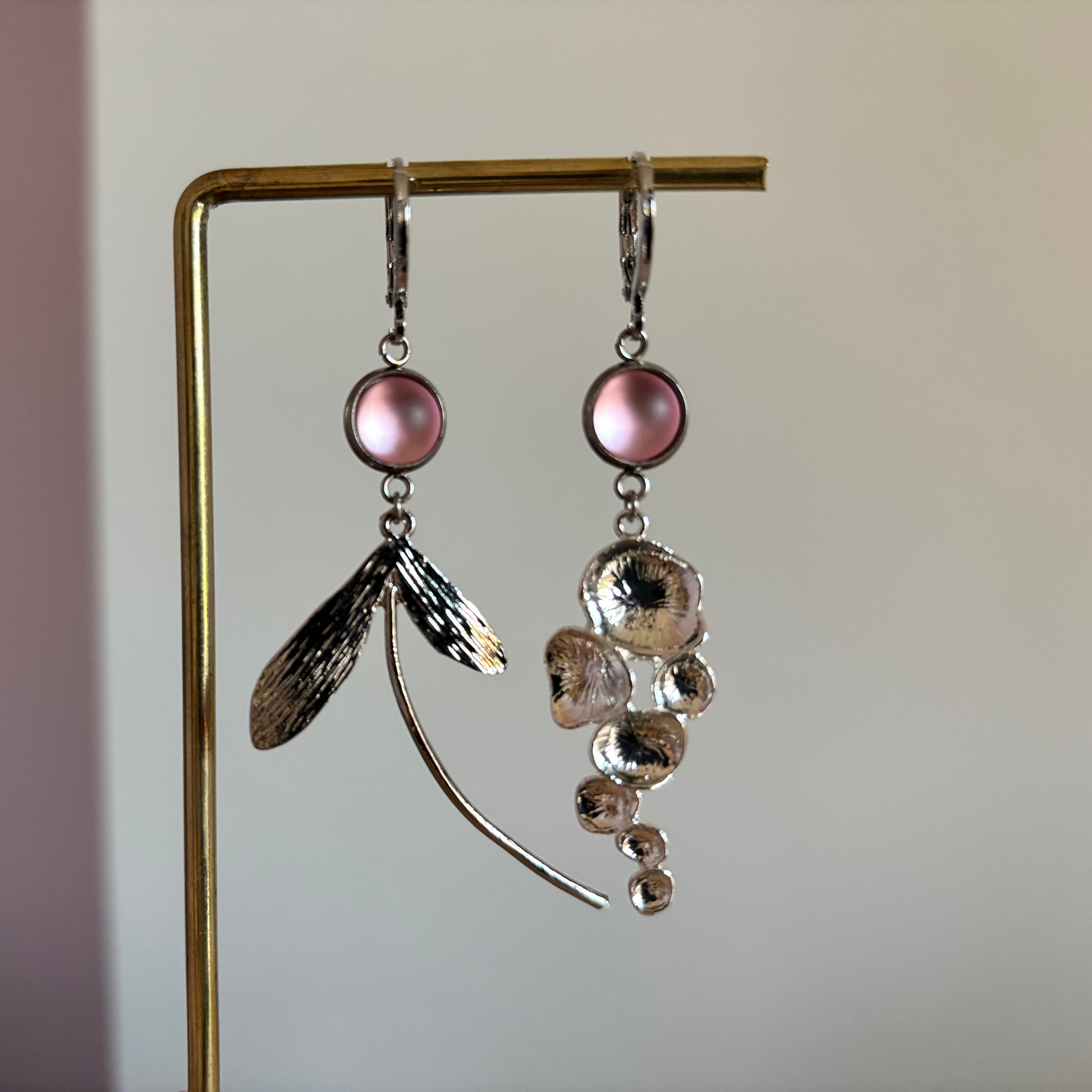 Asymmetrische vergulde oorbellen Abby met rozekleurige cabochon, honingraathanger links en fantasiebedel rechts, circa 5 cm lang