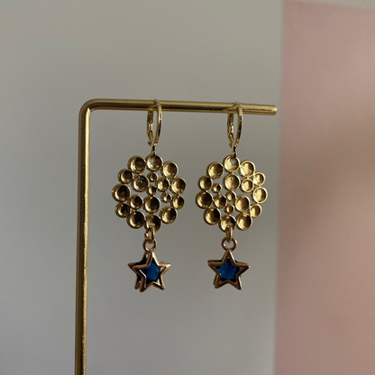 Een foto van de oorbellen "Annabelle"; Een 14k vergulde oorbel met ster en steentje, gecombineerd met een bubbelende hanger, lengte 4 cm.