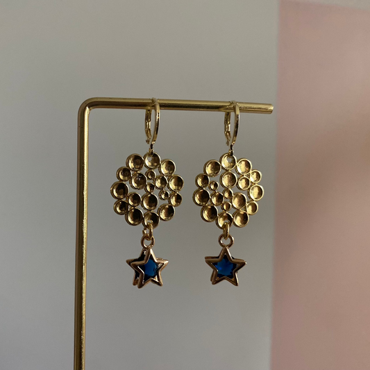 Een foto van de oorbellen "Annabelle"; Een 14k vergulde oorbel met ster en steentje, gecombineerd met een bubbelende hanger, lengte 4 cm.