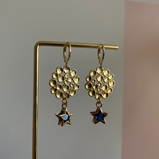 Een foto van de oorbellen "Annabelle"; Een 14k vergulde oorbel met ster en steentje, gecombineerd met een bubbelende hanger, lengte 4 cm.