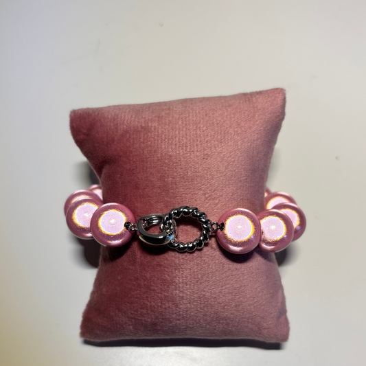 Een kralenarmband genaamd Armband 3D Zilver met ronde, parelmoerroze kralen. De armband heeft in het midden een opvallende zilverkleurige sluiting bestaande uit een gladde ring en een gedraaid zilverkleurig ringetje.