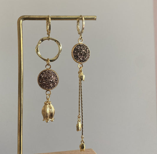 Asymmetrische 14k vergulde oorbellen met rosékleurige glitter cabochon, tulpbedels en een kwastje met mini tulpjes.