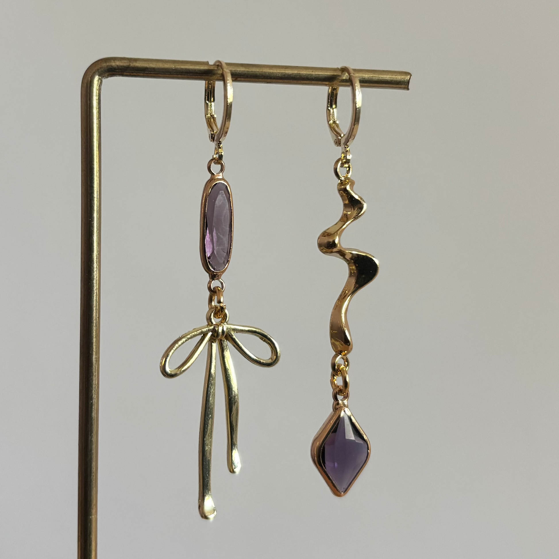 Asymmetrische 14K vergulde strikjes oorbellen met speels design van circa 6 cm