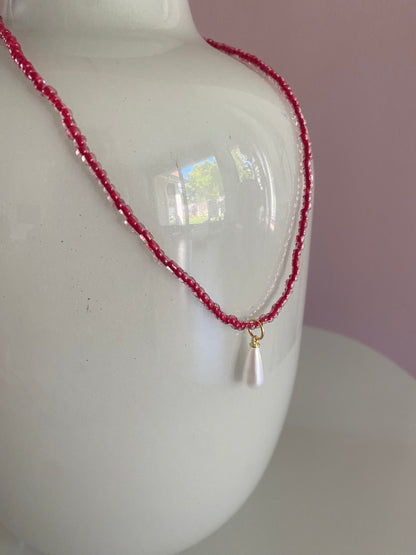 Rode glaskralen of rijstkralen ketting met een parel bedel 